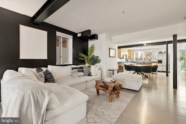 living room featuring light hardwood / wood-style floors and beamed ceiling