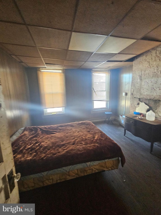 unfurnished bedroom featuring hardwood / wood-style floors and a drop ceiling