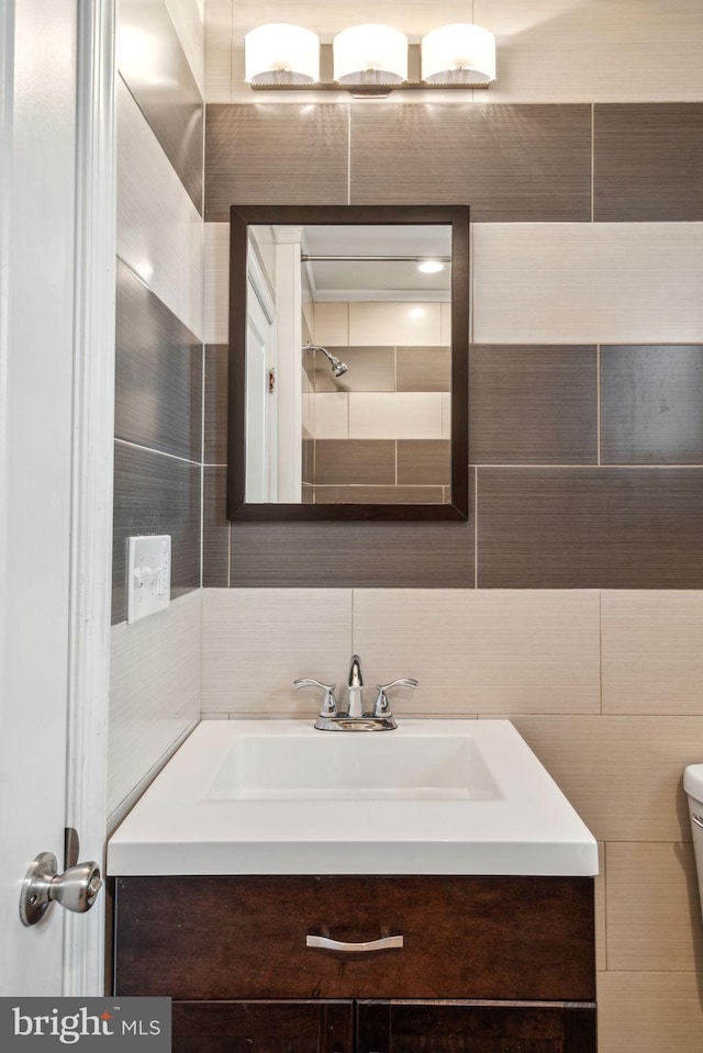 bathroom with tile walls, toilet, and vanity