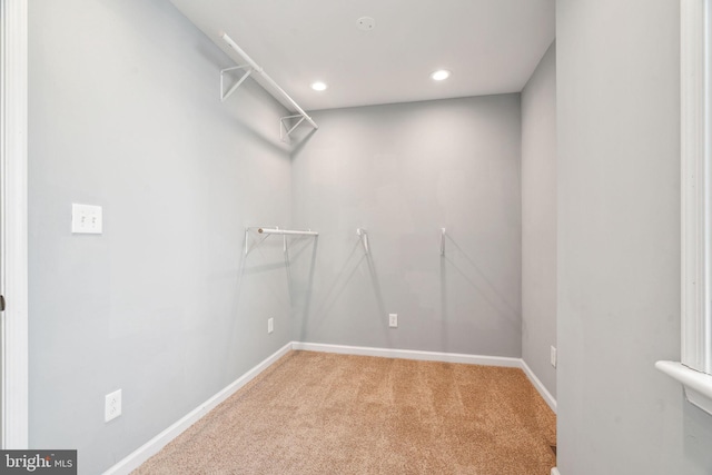 walk in closet featuring light carpet