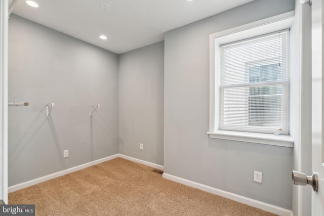 unfurnished room featuring light carpet