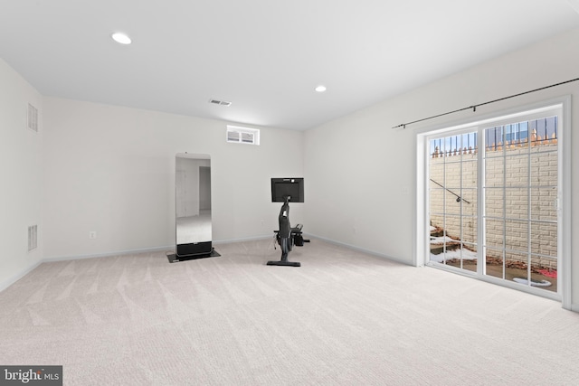 exercise room featuring light carpet