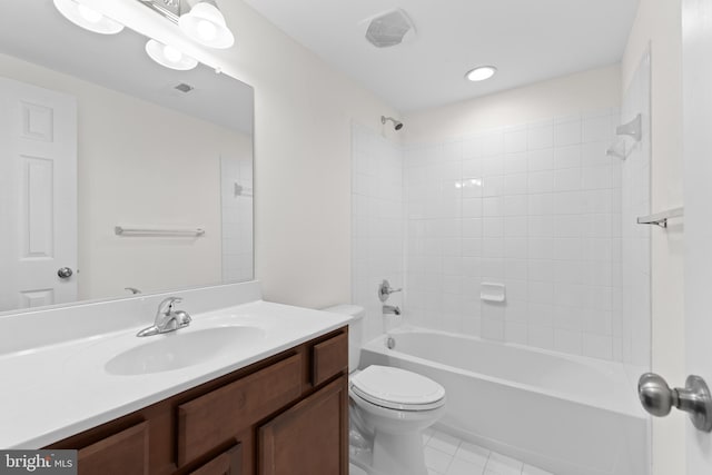 full bathroom featuring vanity, tiled shower / bath, tile patterned floors, and toilet