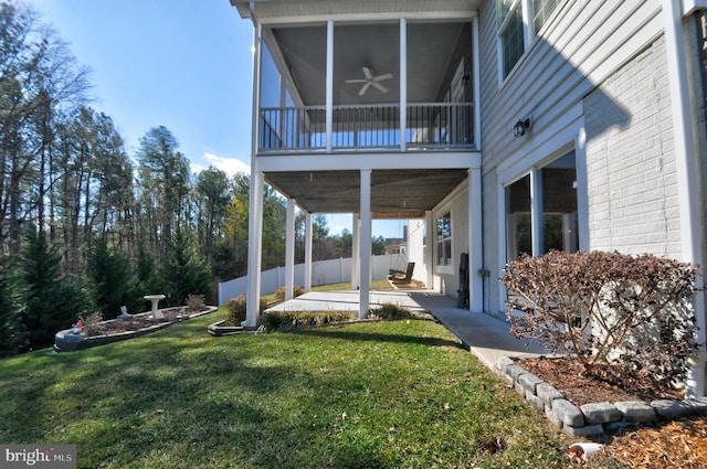 view of yard featuring a sunroom, ceiling fan, and a patio area