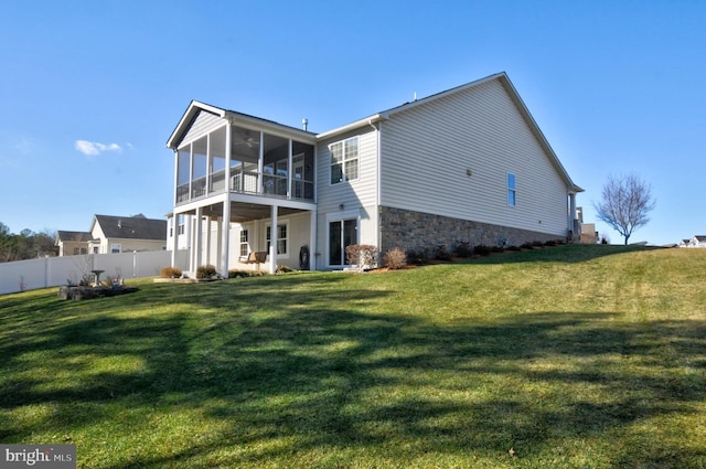 rear view of house with a yard and a sunroom