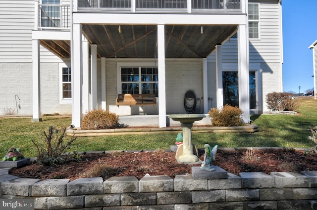 doorway to property featuring a patio area and a lawn