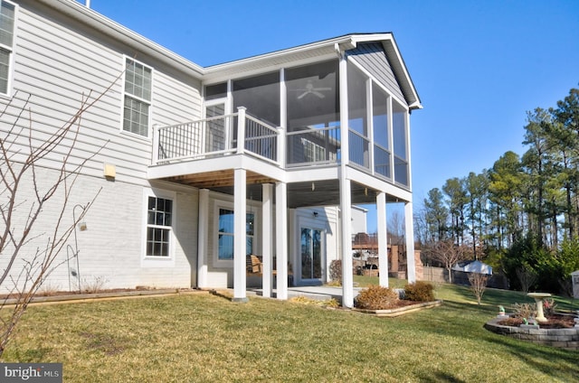 back of house with a sunroom, a patio area, and a lawn