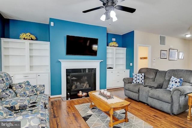 living room featuring ceiling fan and light hardwood / wood-style flooring