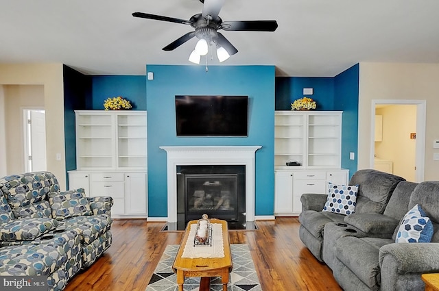 living room featuring wood-type flooring and ceiling fan