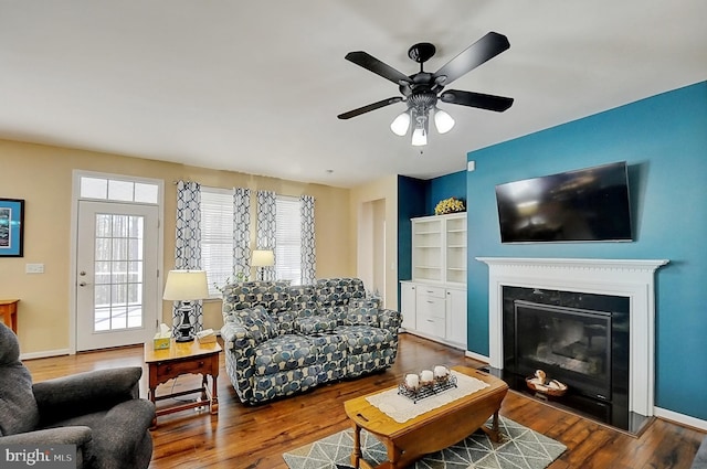 living room with dark wood-type flooring and ceiling fan