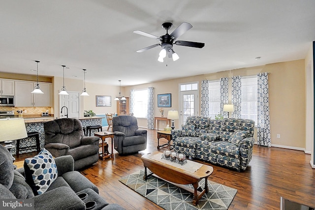 living room with sink, wood-type flooring, and ceiling fan