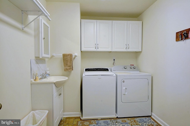 laundry area featuring separate washer and dryer, sink, and cabinets