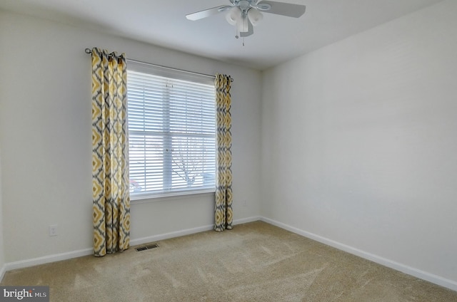 spare room with ceiling fan and light carpet