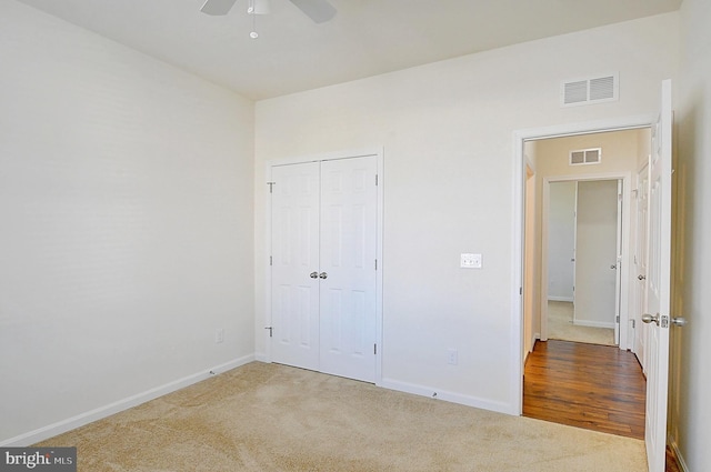 unfurnished bedroom featuring carpet floors, a closet, and ceiling fan