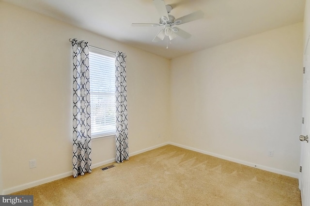 spare room with light colored carpet and ceiling fan