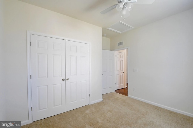 unfurnished bedroom featuring vaulted ceiling, light carpet, ceiling fan, and a closet