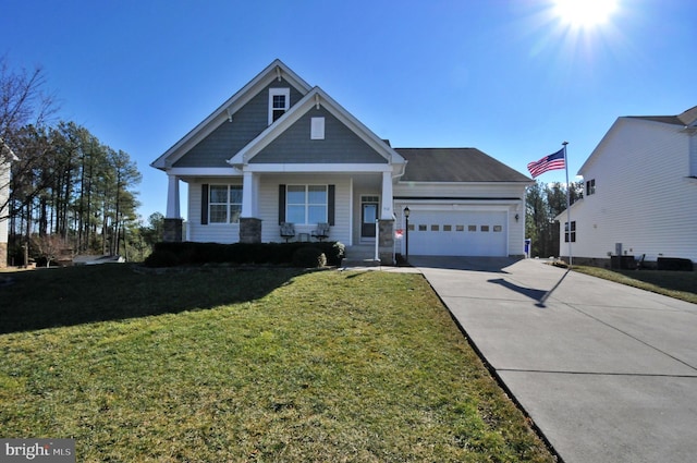 view of front of home featuring a garage, a front yard, and covered porch