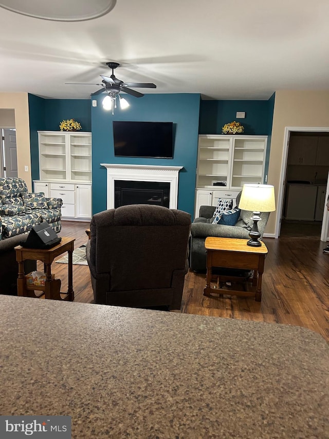 living room with dark wood-type flooring and ceiling fan