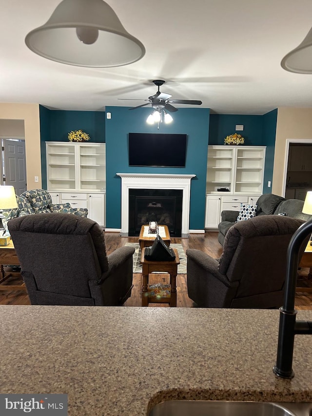 living room with ceiling fan, sink, and dark hardwood / wood-style flooring