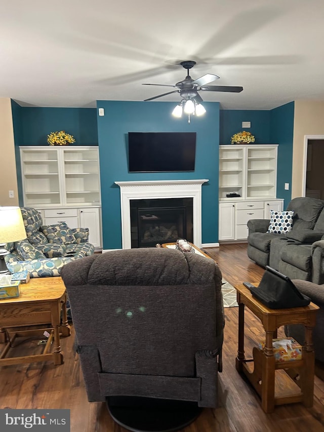 living room featuring dark wood-type flooring and ceiling fan