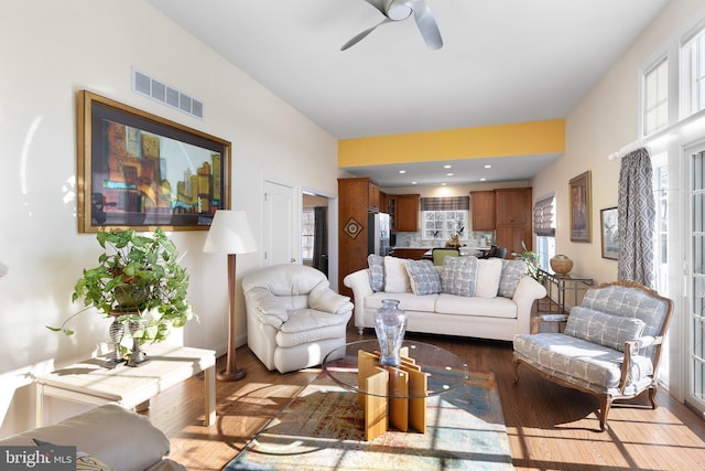 living room featuring ceiling fan and dark hardwood / wood-style floors