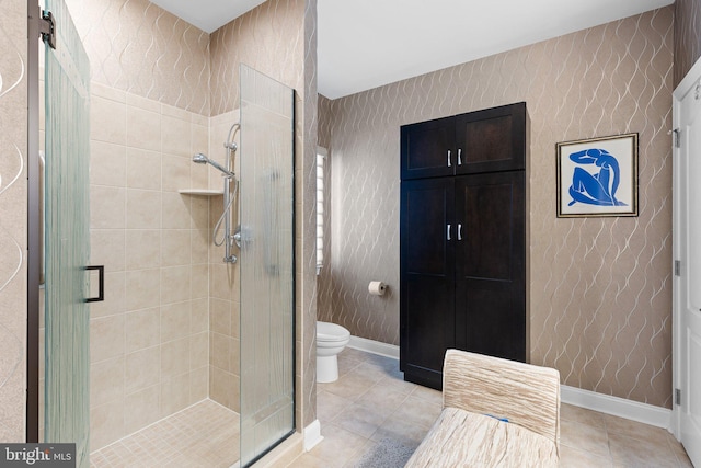 bathroom with a shower with door, toilet, and tile patterned floors