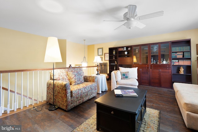 living room featuring ceiling fan and dark hardwood / wood-style flooring