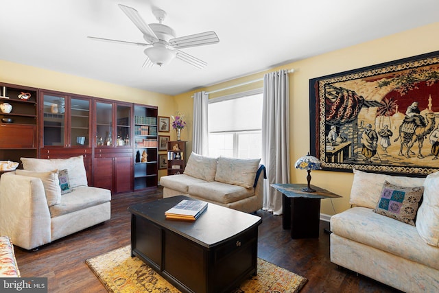 living room featuring ceiling fan and dark hardwood / wood-style floors