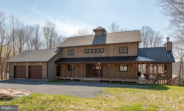 view of front of property with a garage, covered porch, and a front lawn