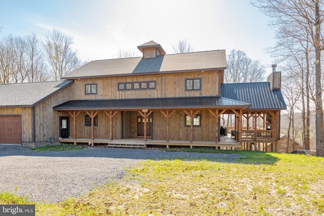 view of front of house featuring a garage, covered porch, and a front yard