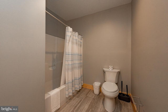 bathroom with wood-type flooring, shower / tub combo with curtain, and toilet