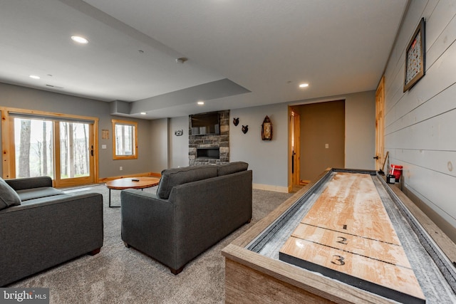 recreation room featuring a stone fireplace and carpet floors