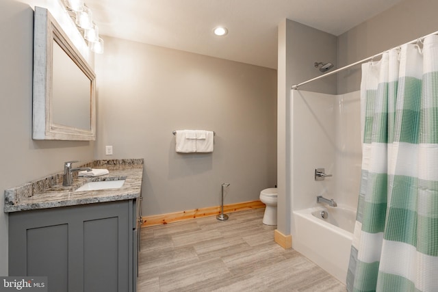 full bathroom with shower / tub combo with curtain, vanity, hardwood / wood-style floors, and toilet