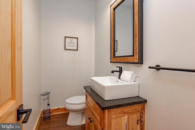 bathroom featuring vanity, hardwood / wood-style floors, and toilet