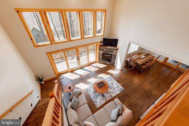 living room with dark hardwood / wood-style floors, a fireplace, and a high ceiling