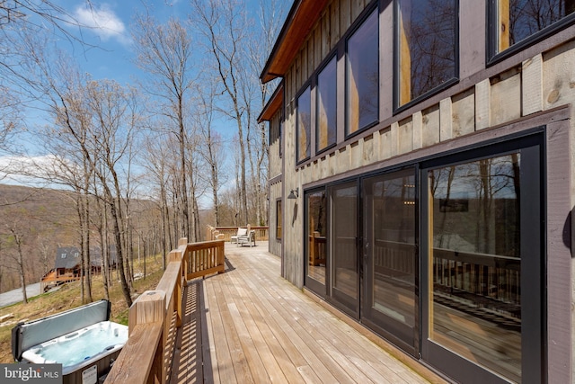 wooden deck featuring a hot tub