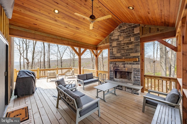 wooden terrace featuring grilling area, an outdoor living space with a fireplace, and ceiling fan