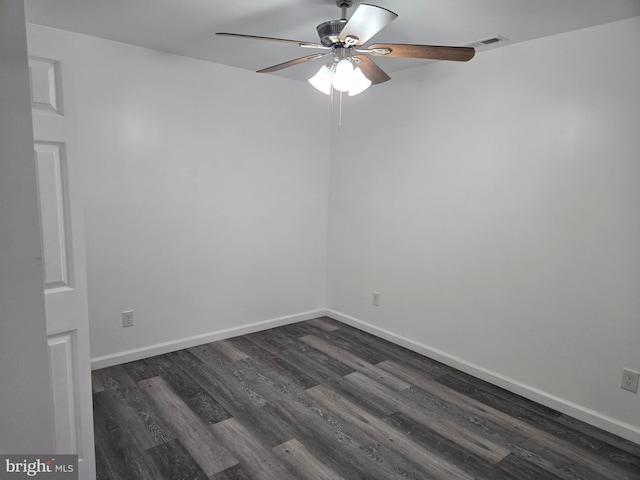 empty room with dark wood-style floors, visible vents, baseboards, and a ceiling fan