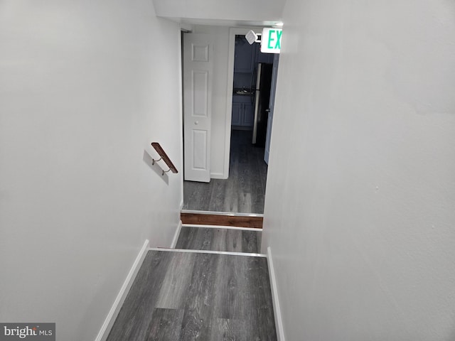 staircase with wood finished floors and baseboards