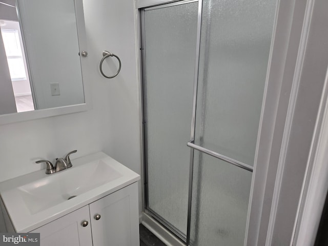 full bath with a shower with shower door and vanity