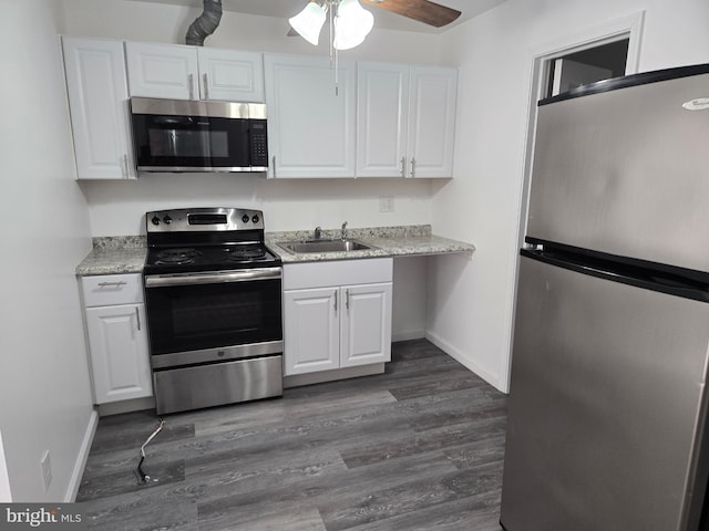 kitchen featuring appliances with stainless steel finishes, a sink, and white cabinetry