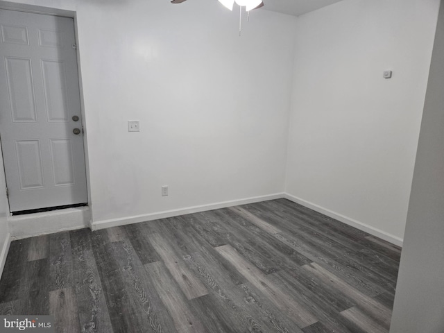 unfurnished room featuring dark wood-type flooring, ceiling fan, and baseboards