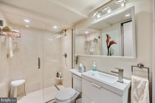 bathroom featuring vanity, toilet, and a shower with shower door