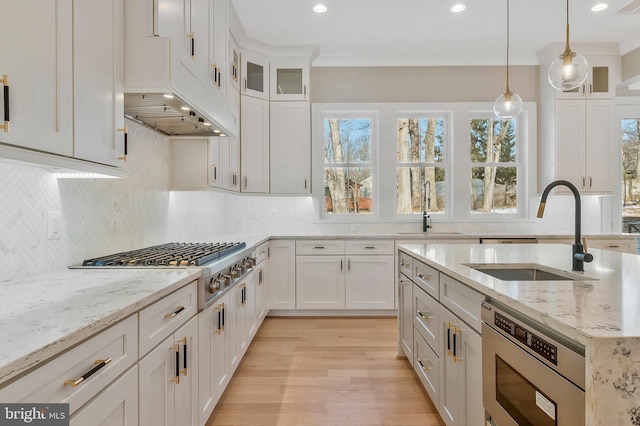 kitchen with light stone countertops, sink, and white cabinets