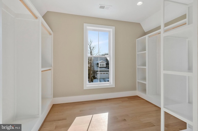 walk in closet featuring light wood-type flooring and lofted ceiling