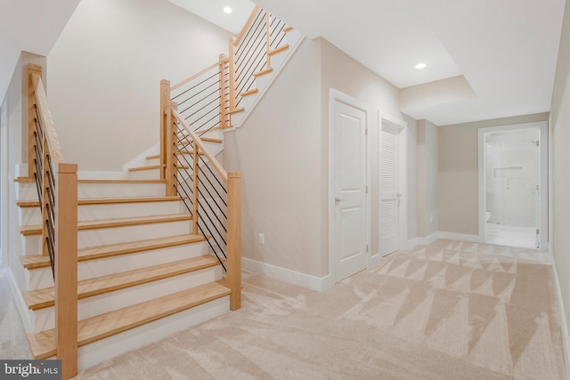 staircase featuring carpet