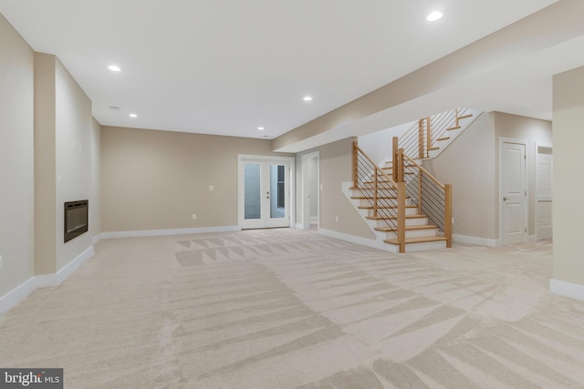 unfurnished living room with light colored carpet, heating unit, and french doors