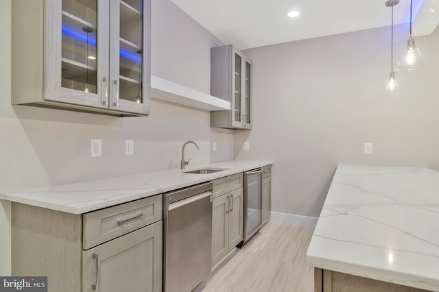 kitchen featuring light stone countertops, decorative light fixtures, sink, gray cabinets, and stainless steel dishwasher