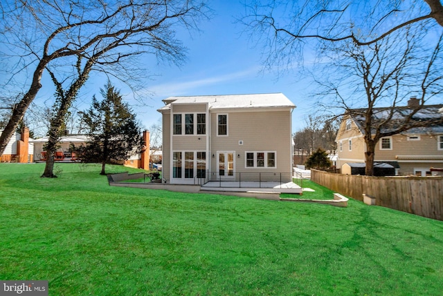 back of property with a patio, a lawn, and french doors