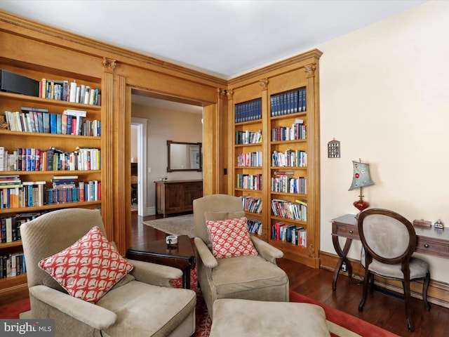 living area featuring built in shelves and dark hardwood / wood-style floors